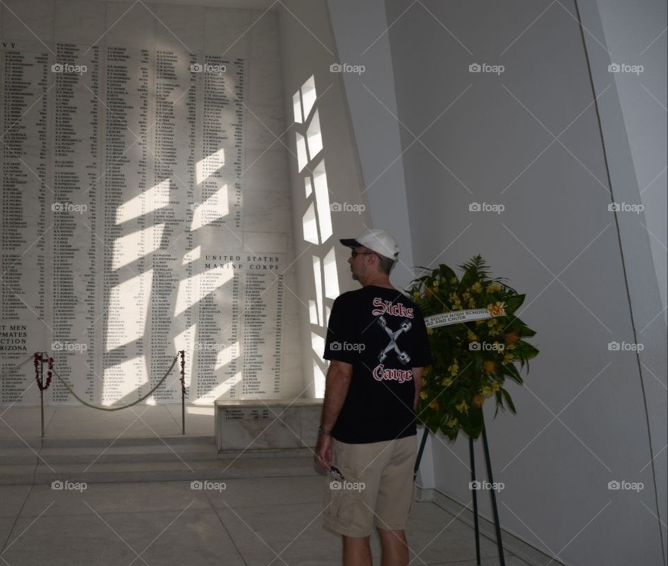 Reading the Arizona Memorial wall in Pearl Harbor Hawaii