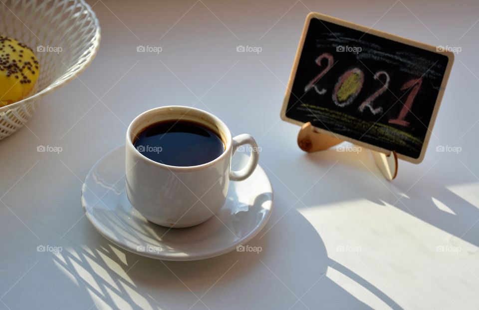 coffee cup on a white table background, 2021, beautiful sunlight and shadows