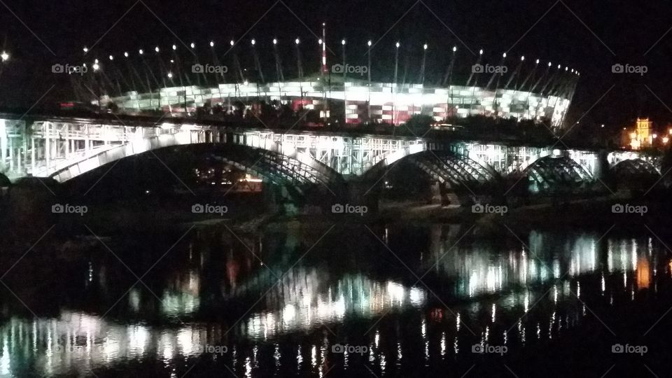 Bridge in Warsaw by night. Lights in Warsaw. Vistula river and National stadion