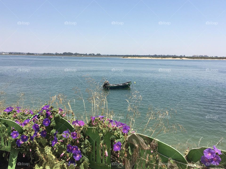 Unique boat in large river with flowers on garden chairs