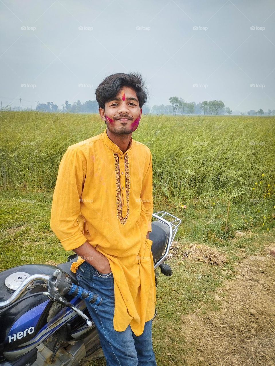 a portrait of Indian boy with yellow kurta and colourful face