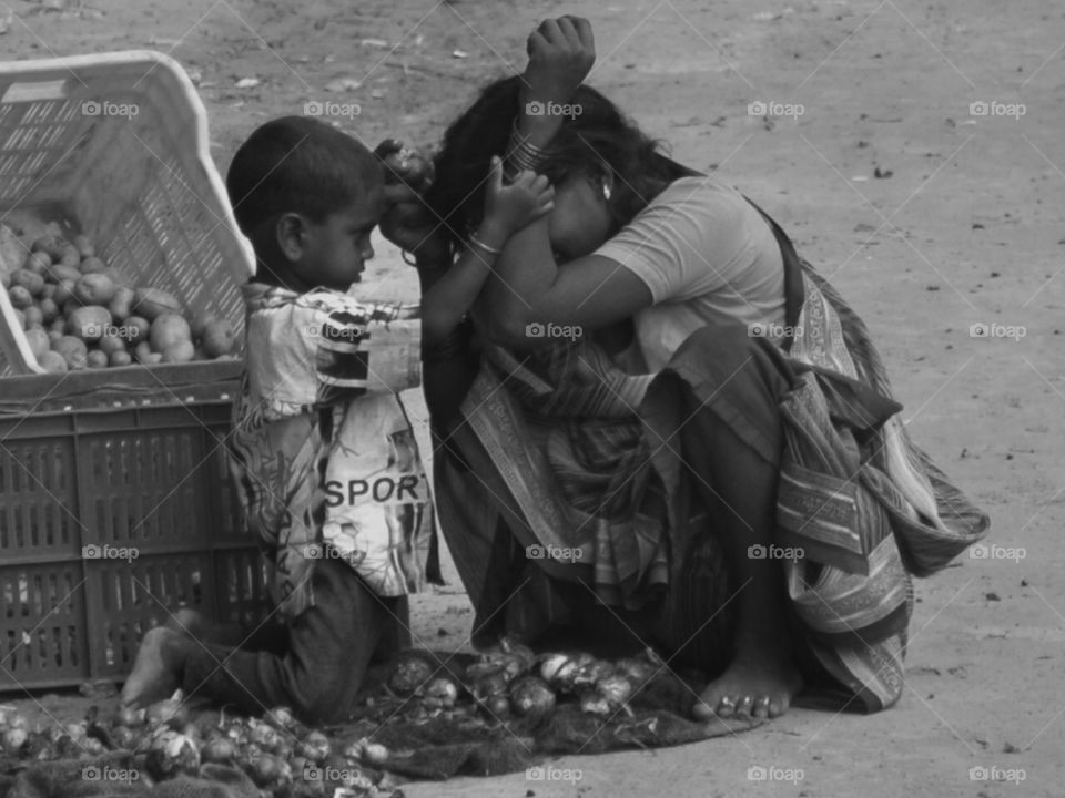 poverty. this mother and child lived on the road side in New Delhi. in spite of all hardships they have moments of happiness.