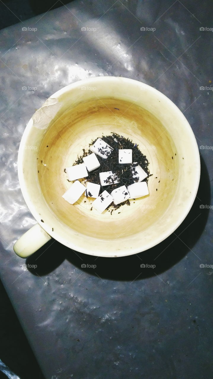 tea leaves of tea and sugar cubes in a cup