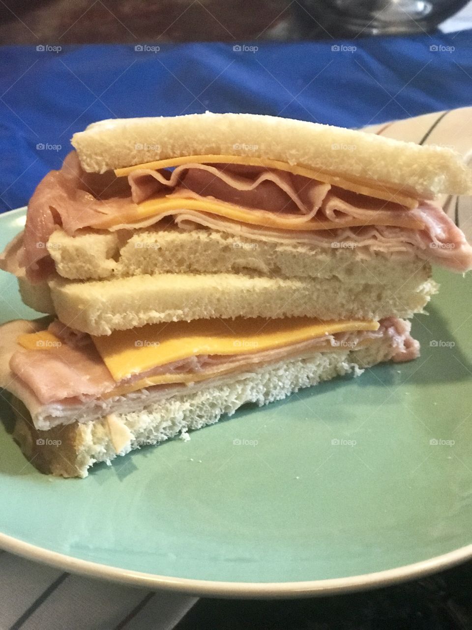A ham and cheddar cheese sandwich on white bread on a plate served for lunch. USA, America