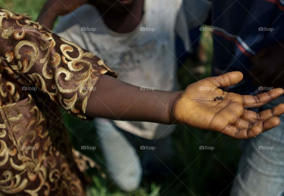 A young Liberian boy shows soldiers an ant he caught, Voinjama, Liberia, Dec. 09, 2014. During Operation United Assistance, the joint effort to contain the 2014 Ebola outbreak.