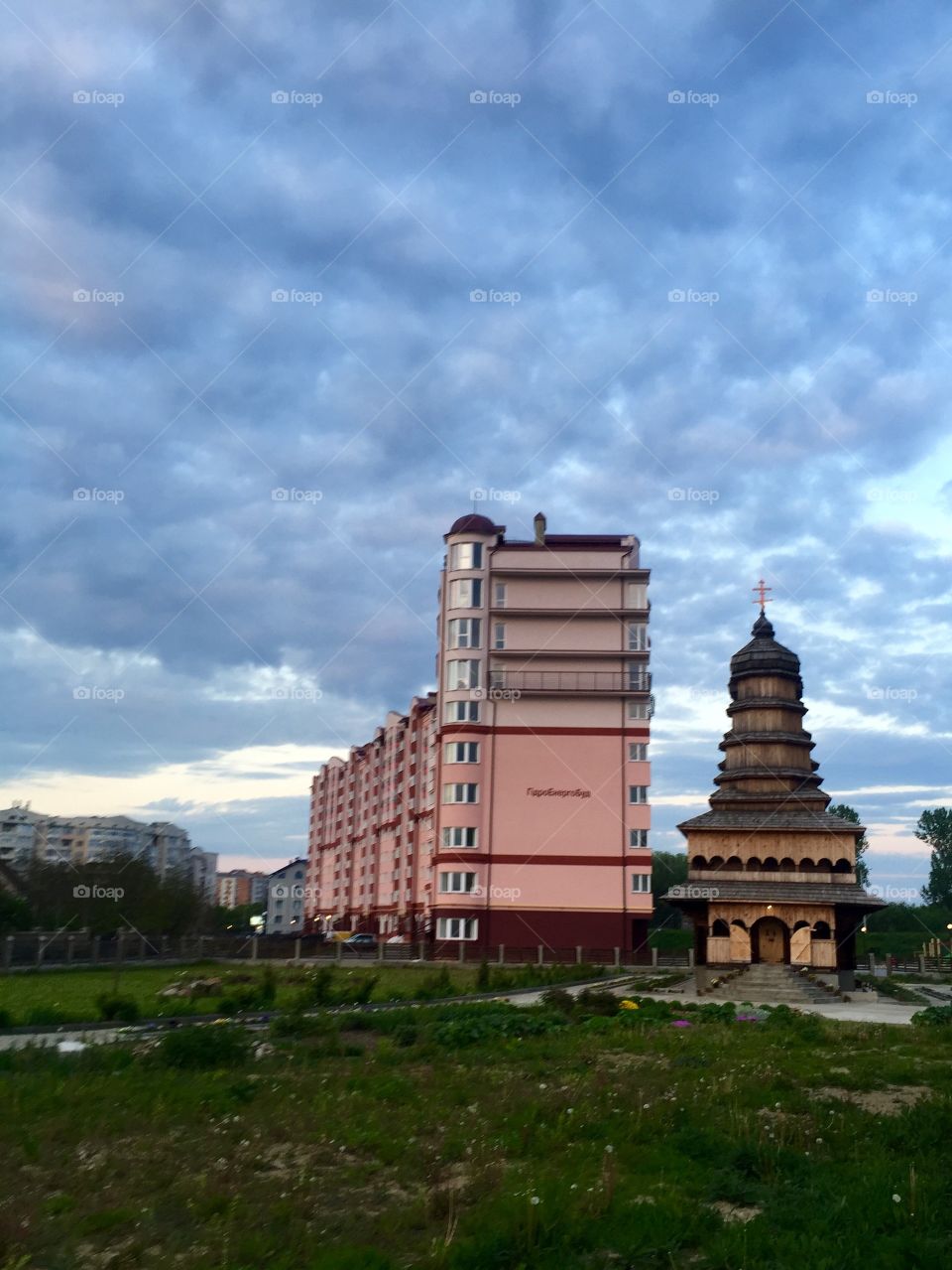 An old wooden church and a modern apartments building