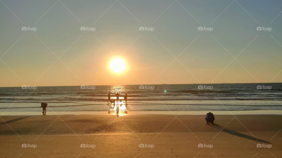 Everybody is busy enjoying the vacation at the beach in their own way