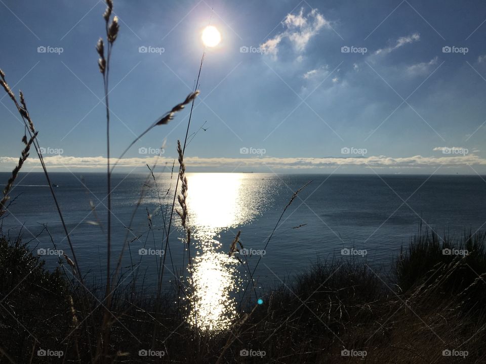 Sun illuminating the ocean and the coastline