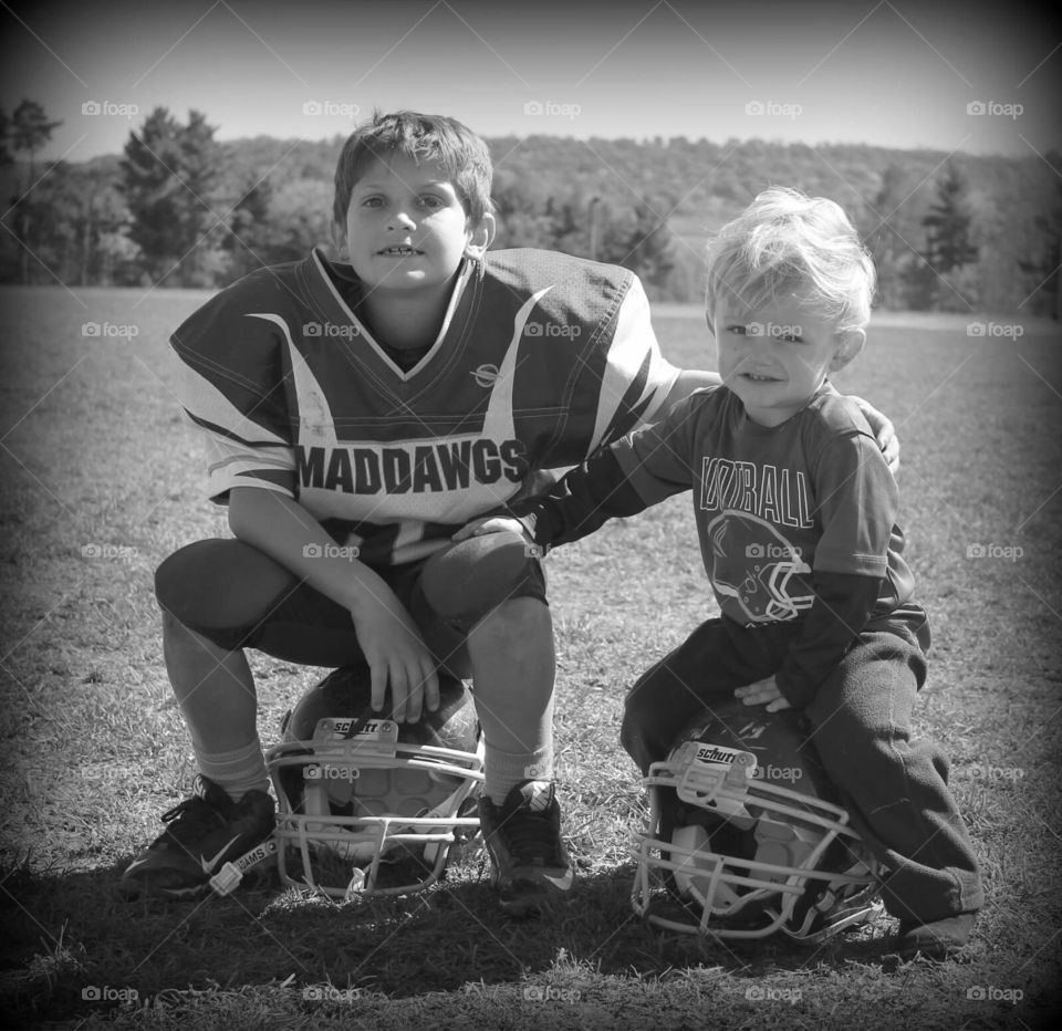 American football players sitting on helmet at field