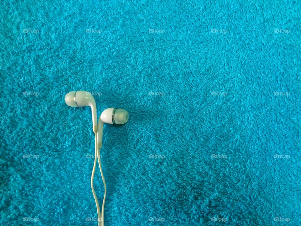 Earphones on blue background, earphones for listening digital music.
