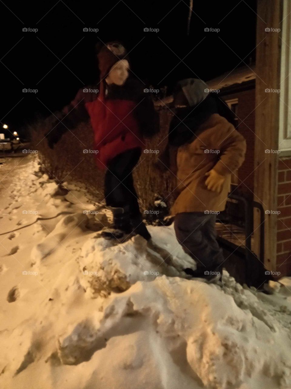 kids in snow pile nighttime.