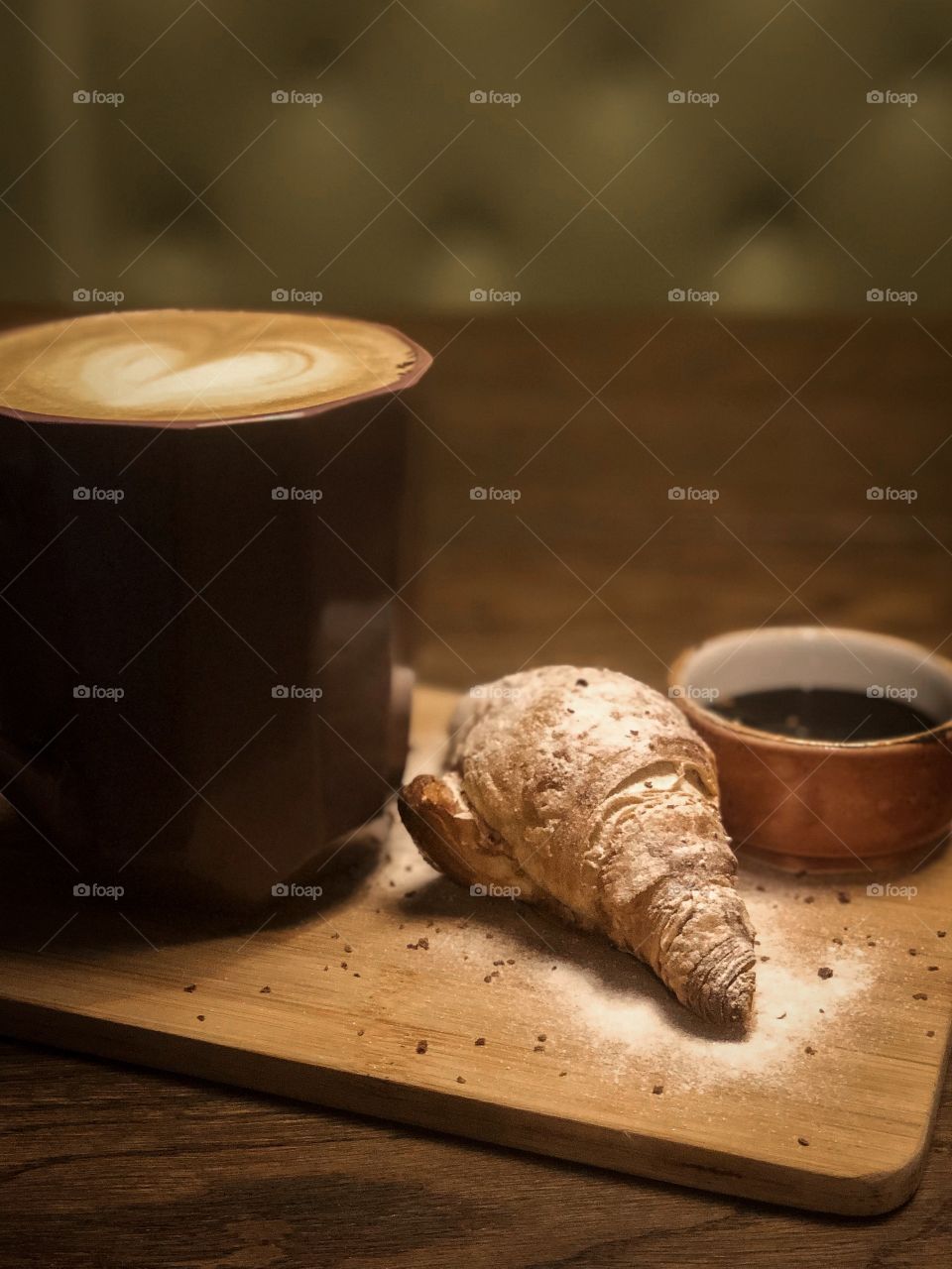Cup of cappuccino with fresh made croissant 