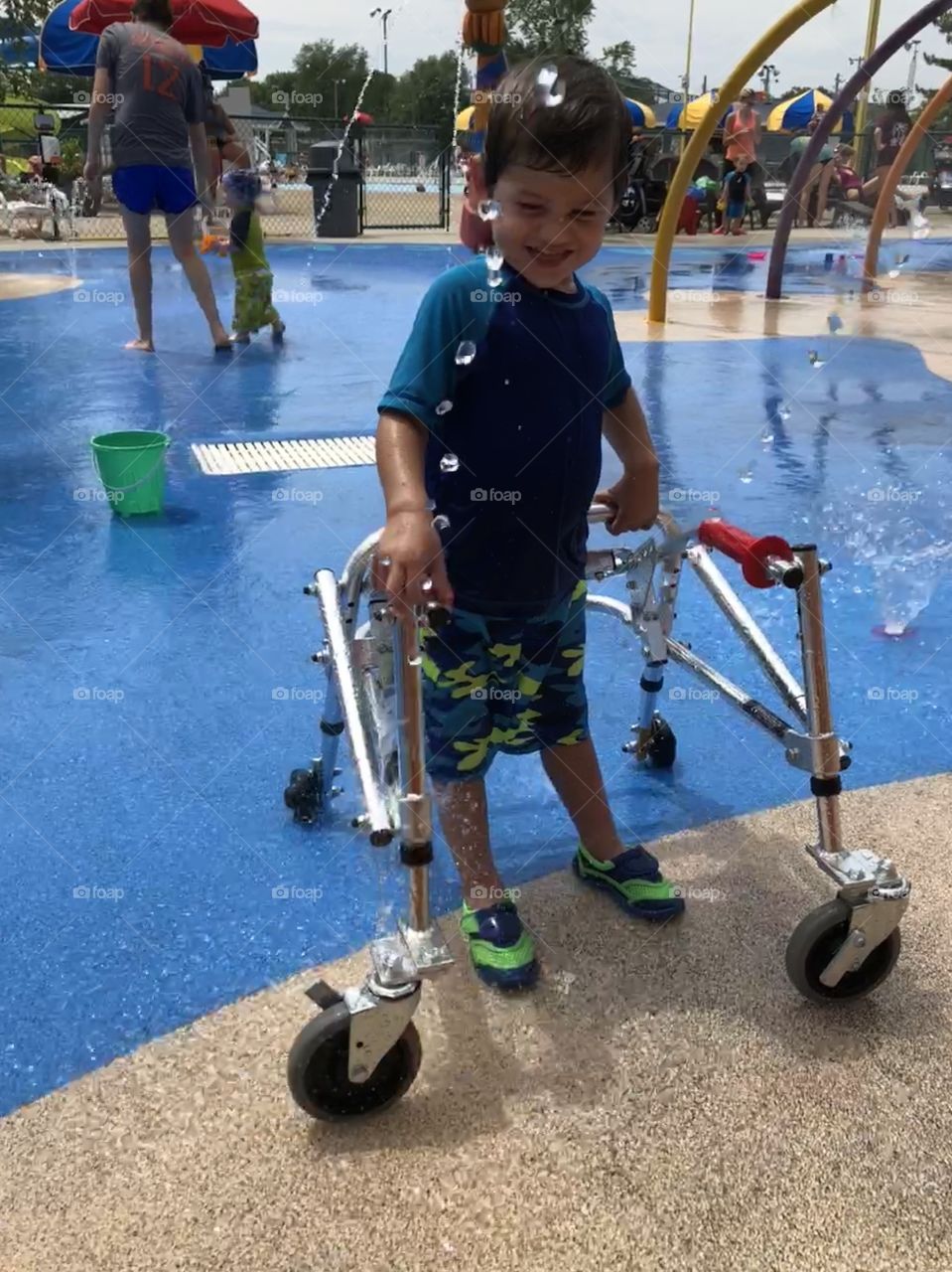 Special needs boy with walker enjoying time at water park