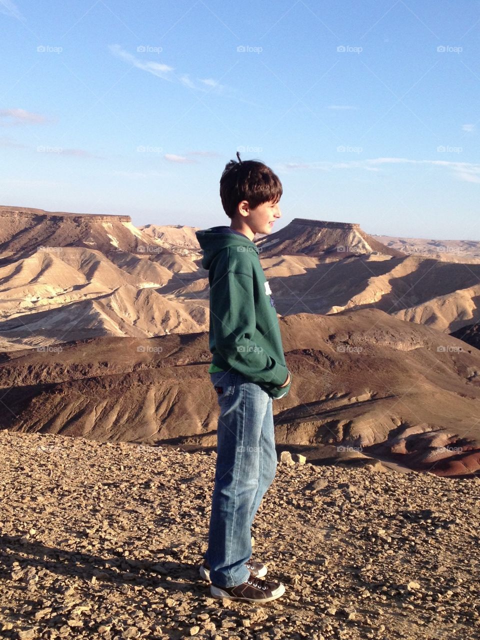 Smiling boy standing in desert