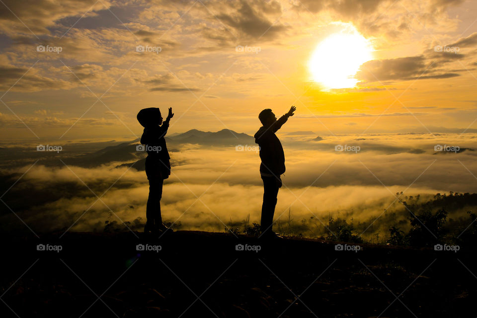 Couple under sunrise at Mandiangin, South Borneo, Indonesia.