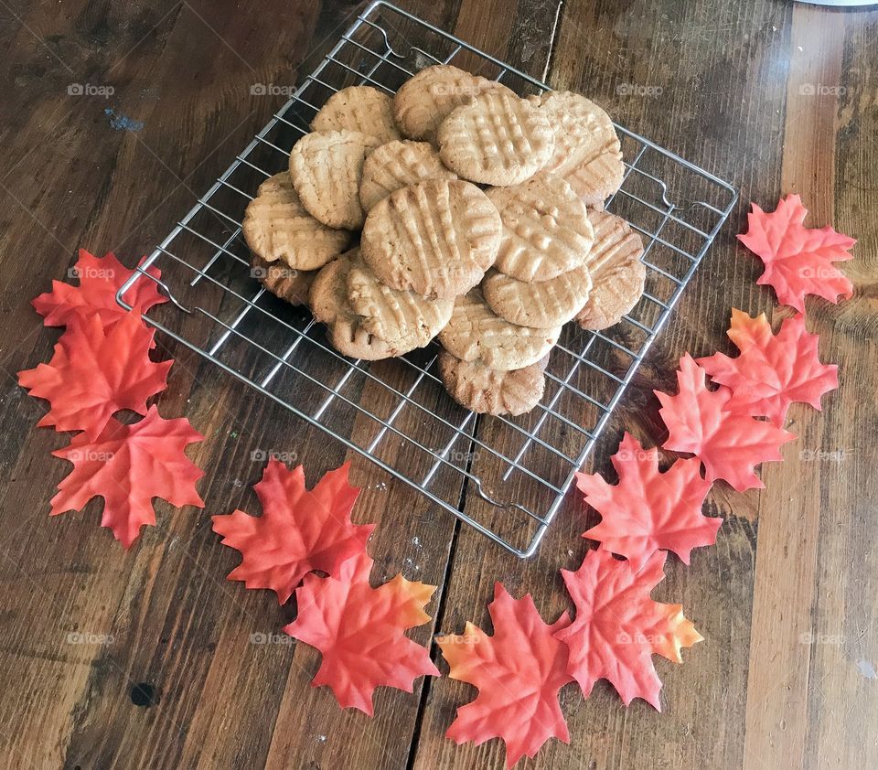 Flatlay Golden Brown Peanut Butter Cookies on a cooling rack with Maple leaves surrounding 