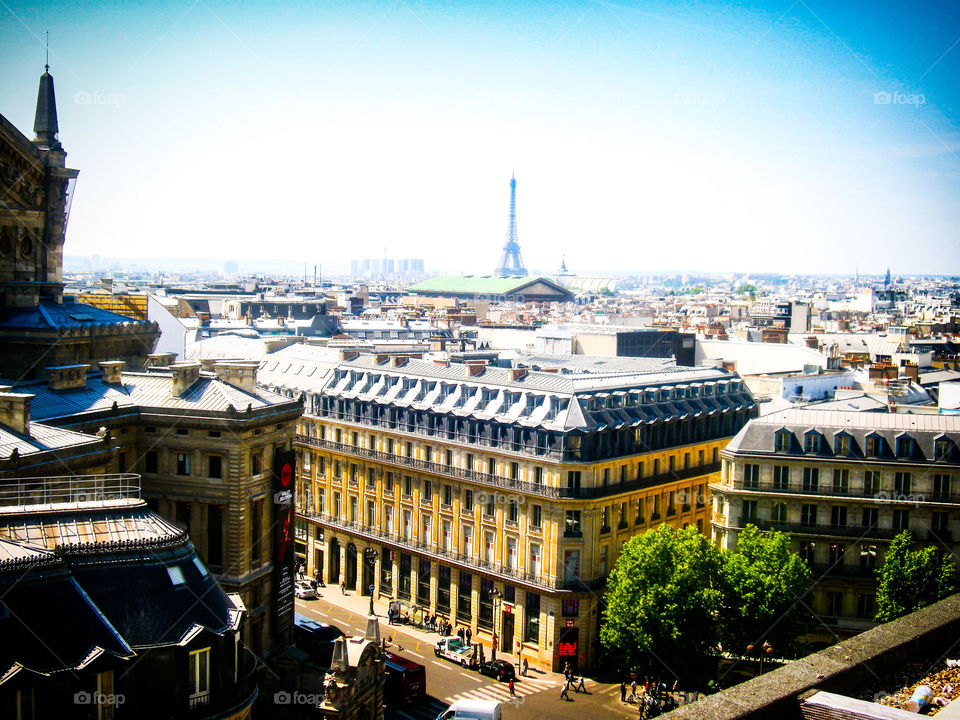 Una increíble vista de Torre Eiffel de París de fondo representada en la imagen . El sol ilumina los edificios dorados con tejados oscuros de la arquitectura clásica del siglo XVIII. La ciudad más romántica del mundo invita a quedarse ahí un rato más