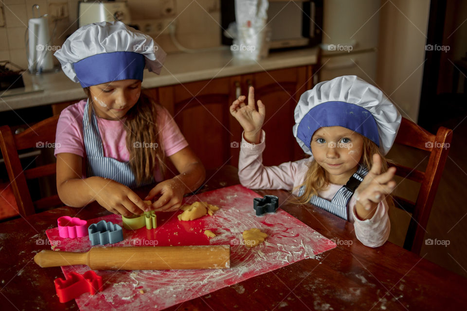 Little sisters cooking the biscuits 