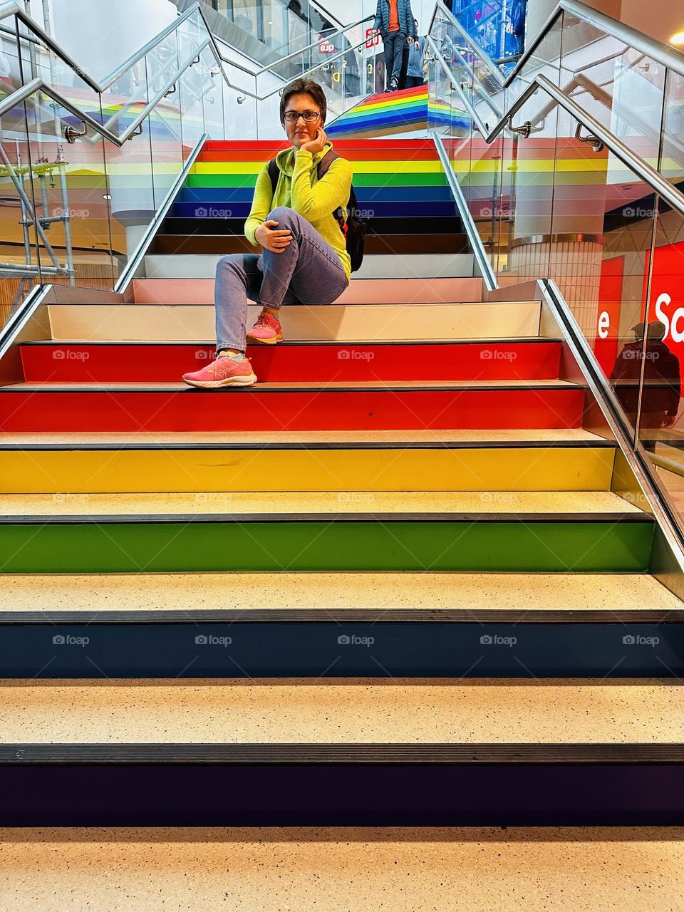 Portrait of beautiful young woman in tge city. LGBT symbol, rainbow stairs in mall. Pride parade in Toronto.