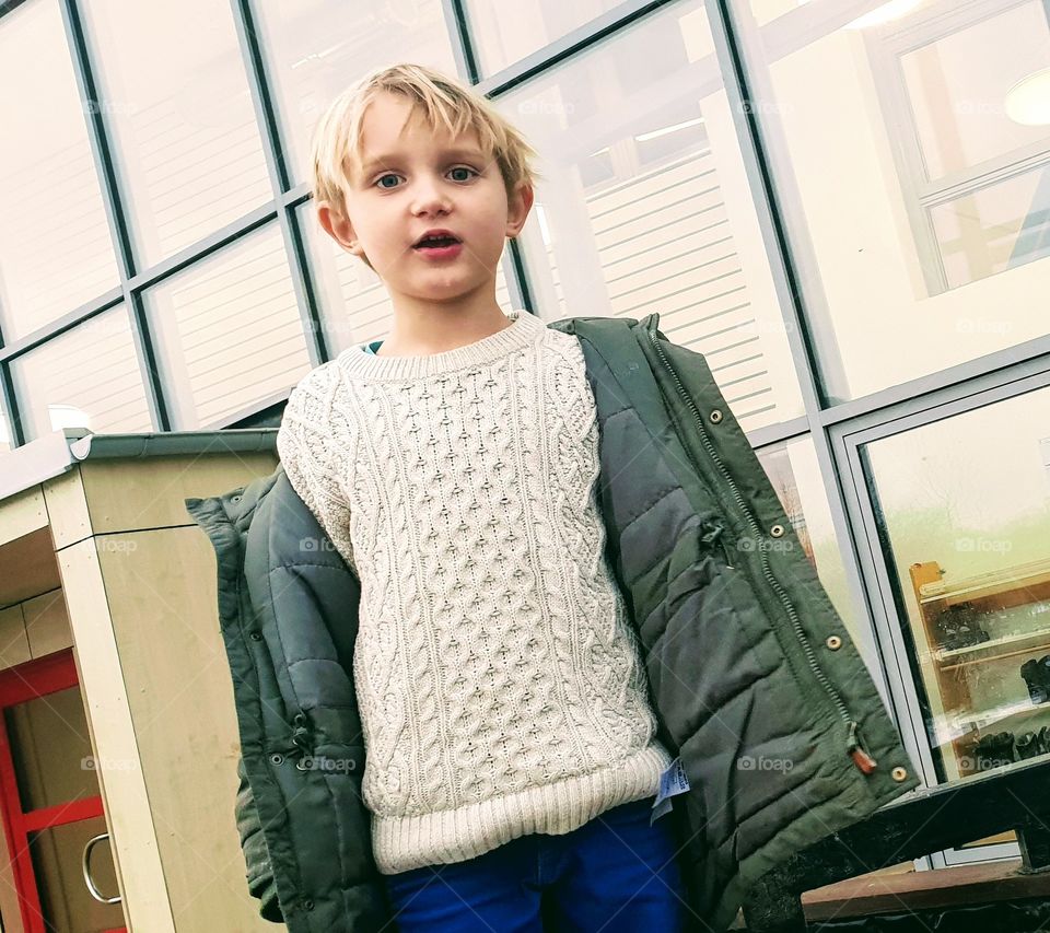 Boy with glass windows in the background