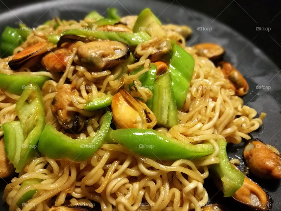Spicy noodles with mussels, green peppers, oil and seasoning. Easy, simple and fast homemade cooking food. Seafood dishes.