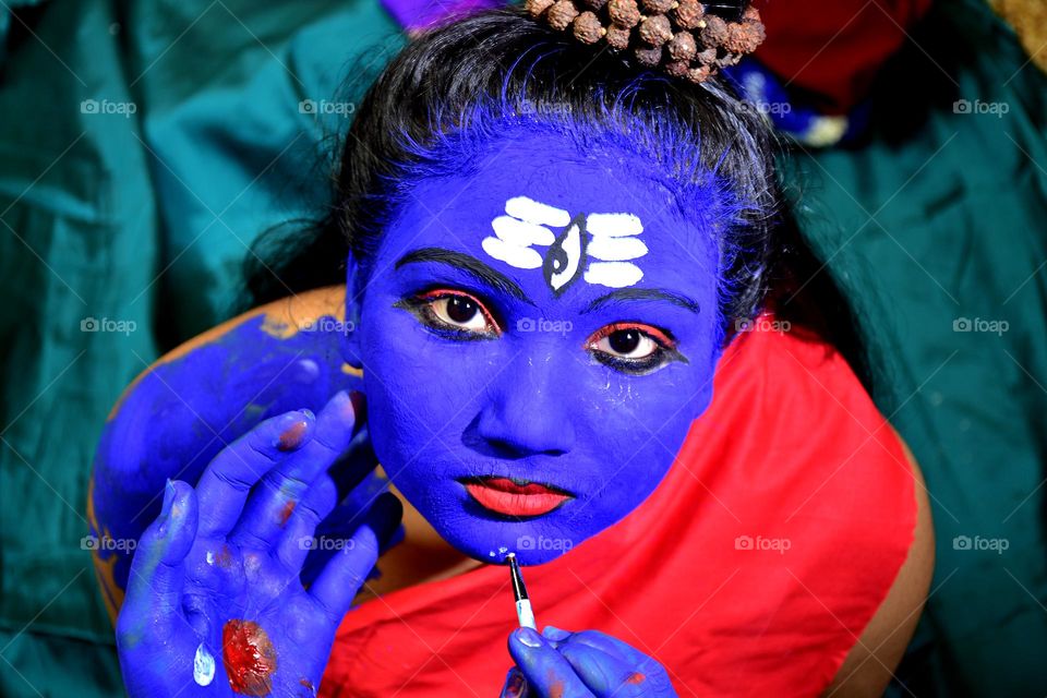 A young Indian girl painted as Shiva at a festival of Shivratri