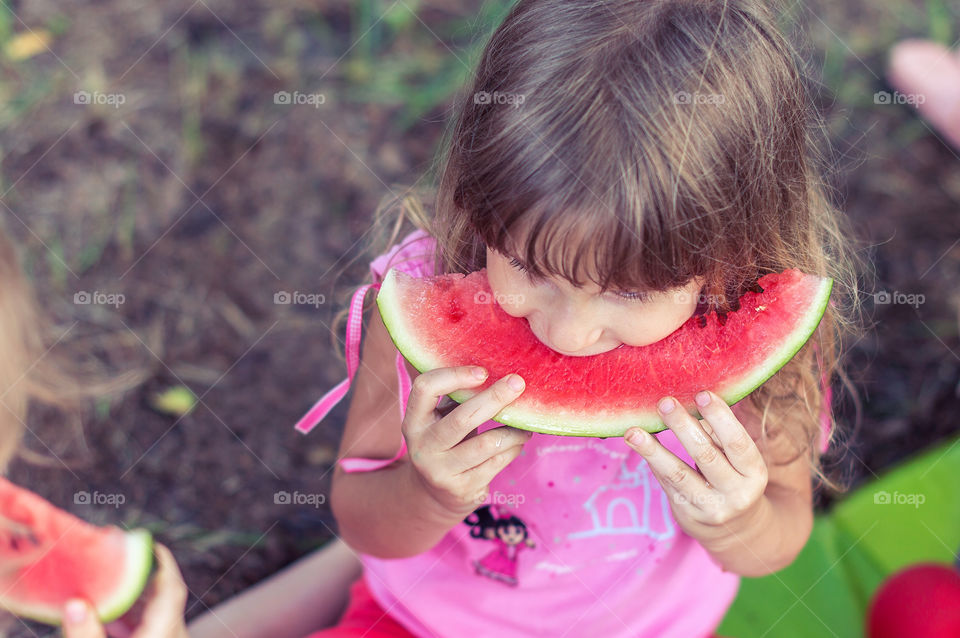 Little girl is eating watermelon