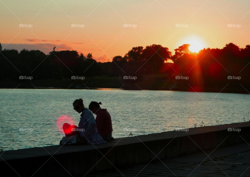 two on a sunset river shore