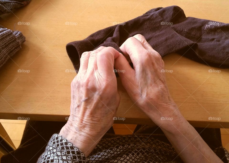 hands of an old woman sorting socks