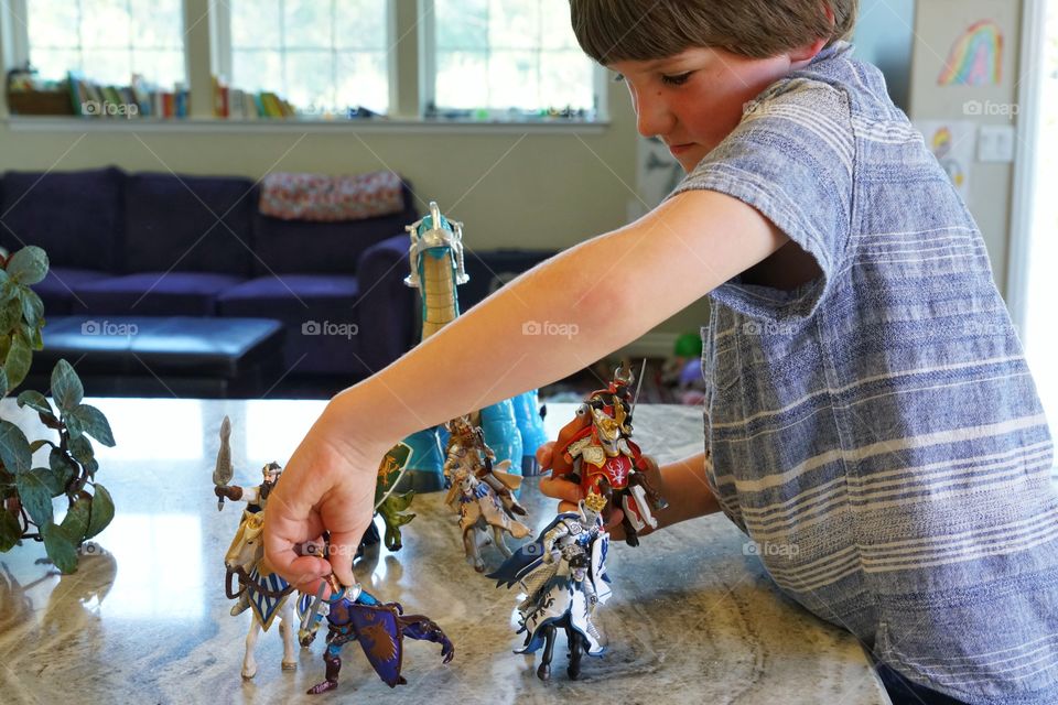 Young Boy Playing With Toy Knights
