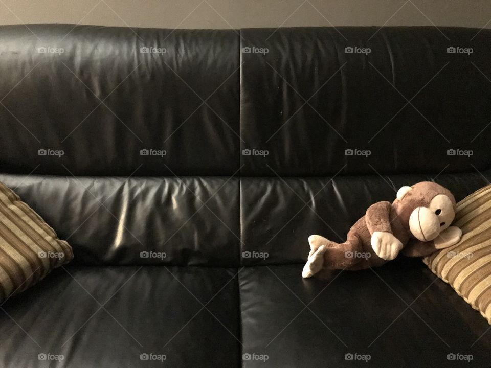 Stuffed monkey sleeping on a couch