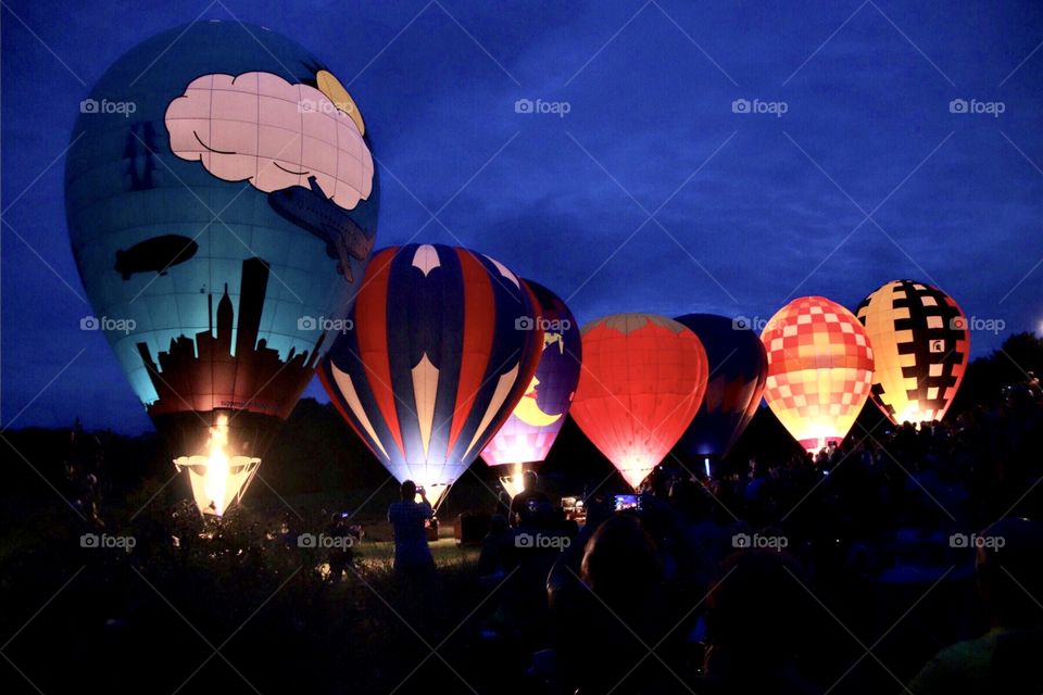 Colorful hot air balloons light up at dusk