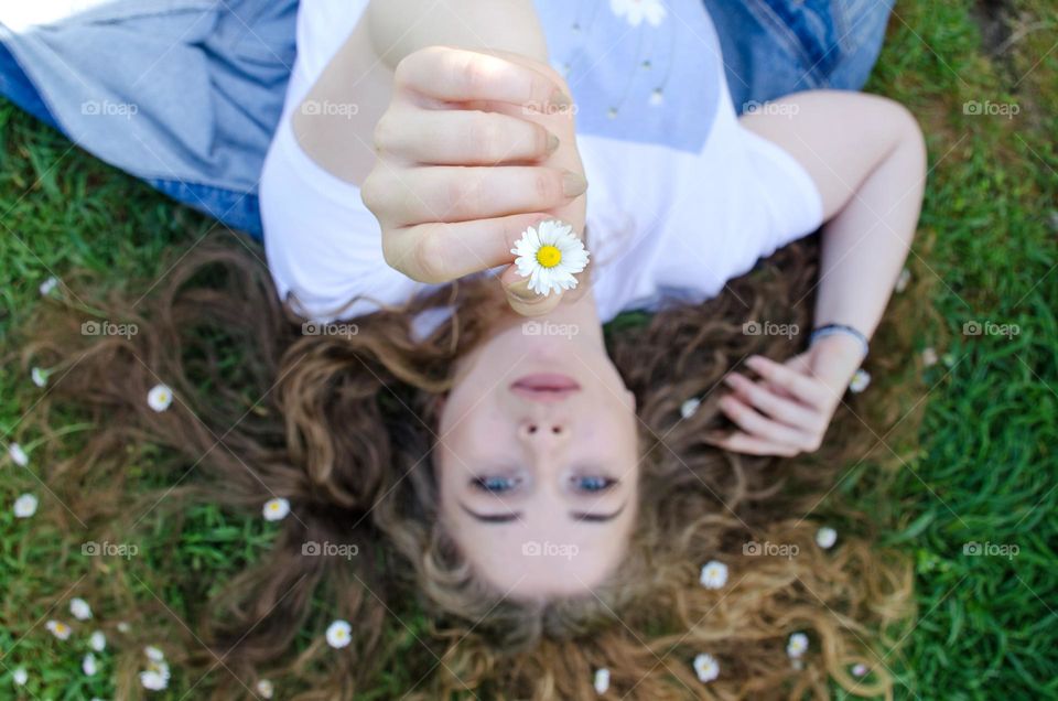 Portrait of a Beautiful Young Girl on Background of Daisies