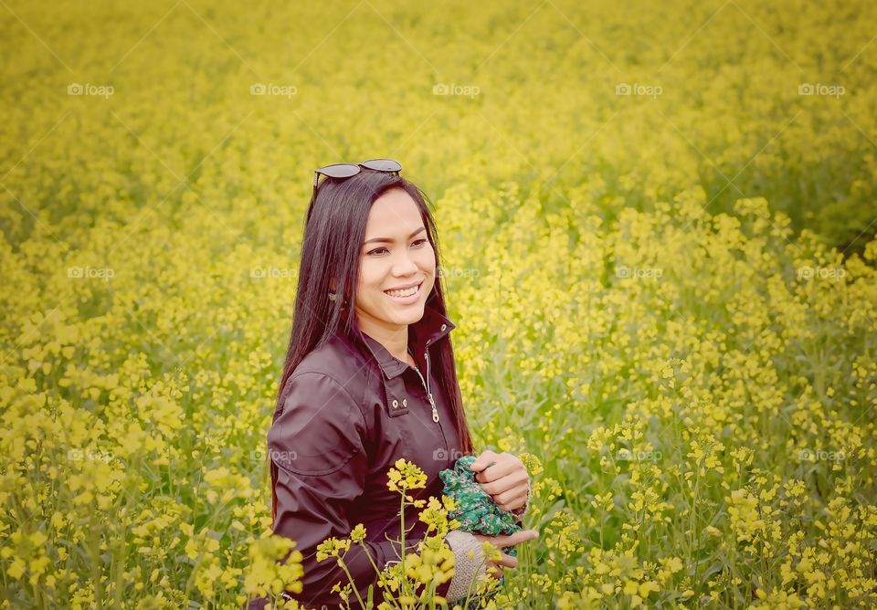 Young woman in yellow rapeseed field