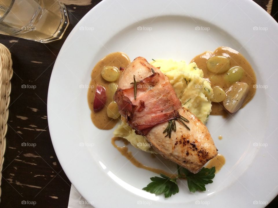 Chicken wrapped in bacon with grape sauce 