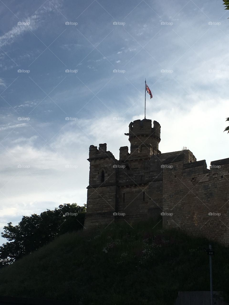 The observatory tower on a motte mound at Lincoln Castle flying the flag against a summer sky 