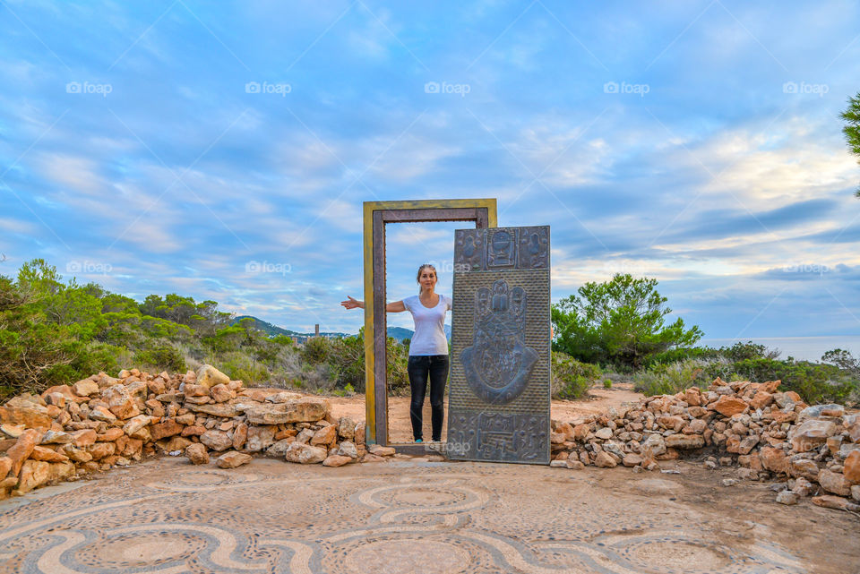 Woman standing near ancient door