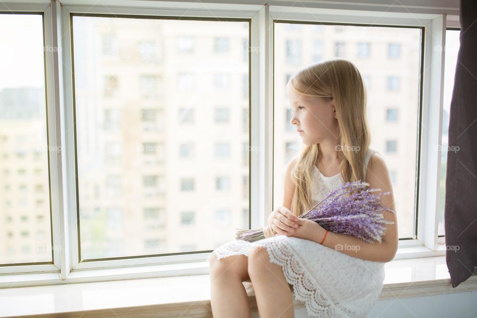 Little girl looking through the window 