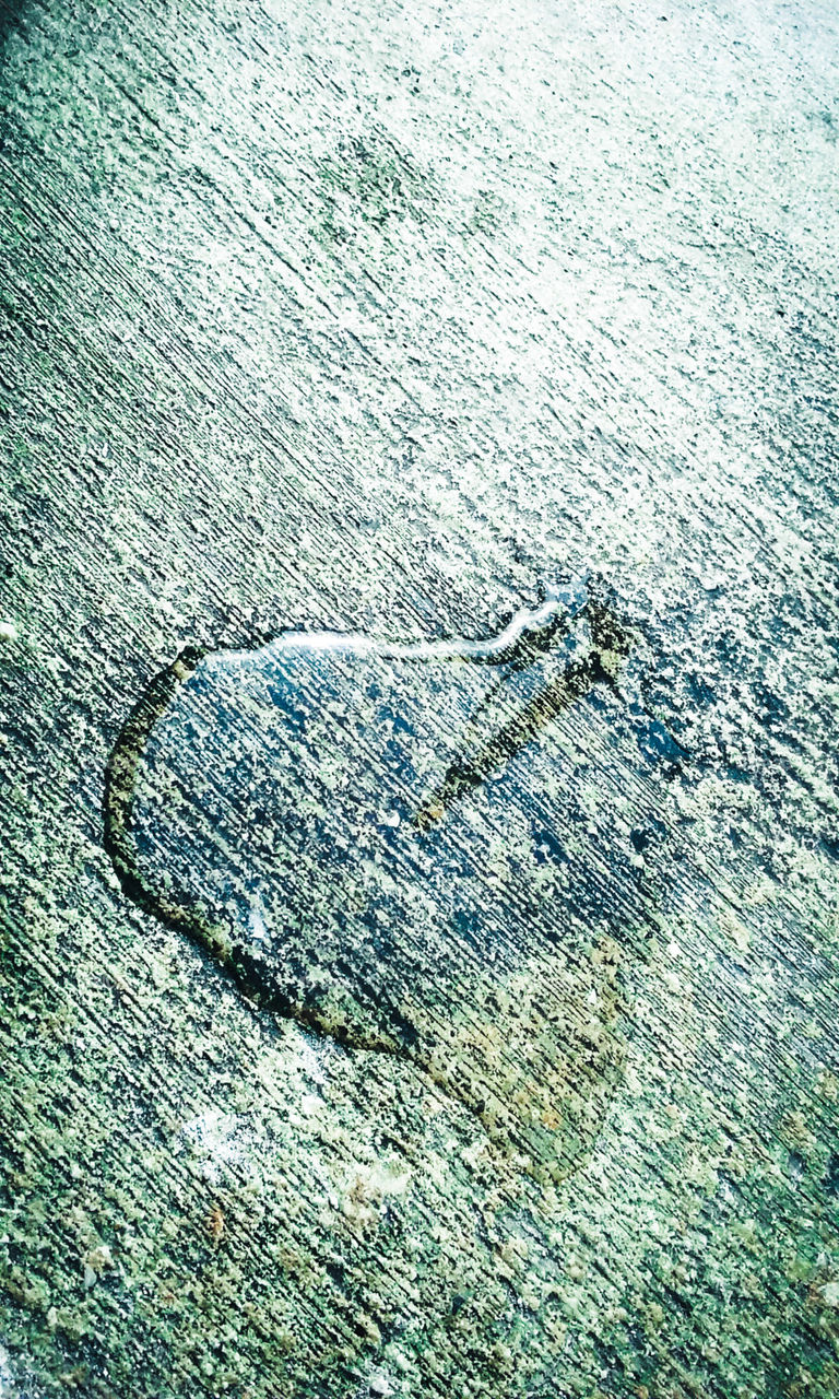 Heart shaped water drop on street pavement