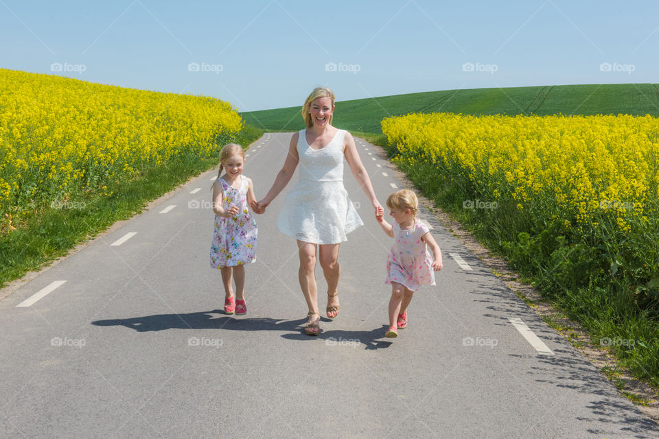 Woman walking with her two daughters on countryside road