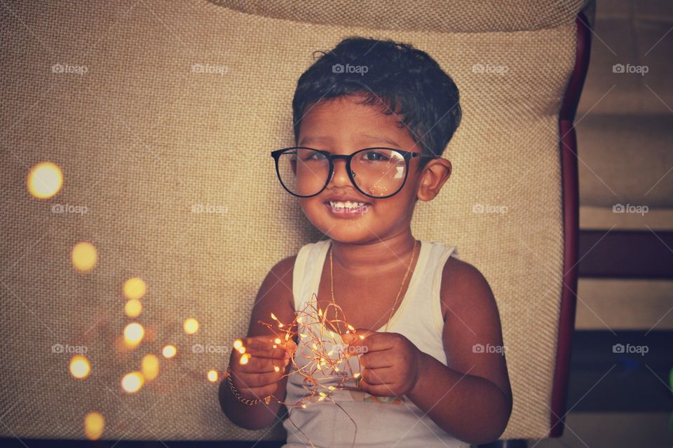 little baby with fairy lights and big glasses