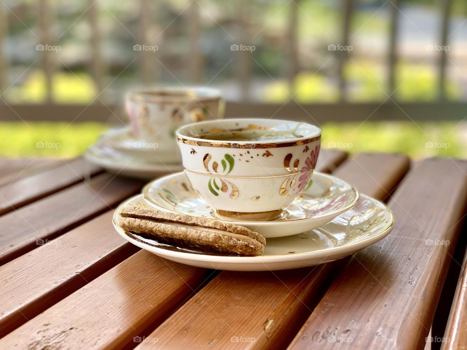 Cup of tea on summer day patio with biscuit 