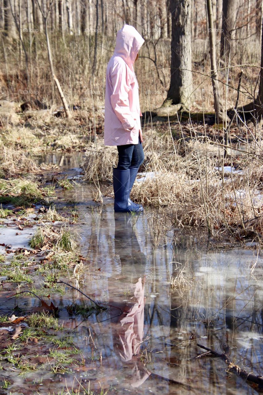 Seeing double girl walks in frozen pond her reflection in icy ground 