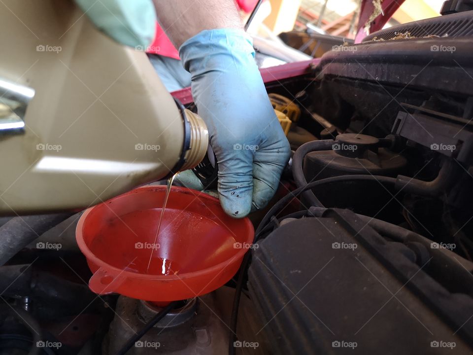 Mechanic pours oil into the vehicle