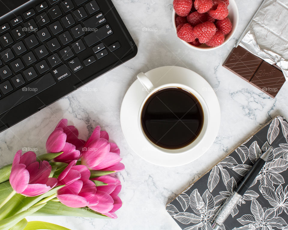 A cup of coffee with chocolate, berries and notebook 