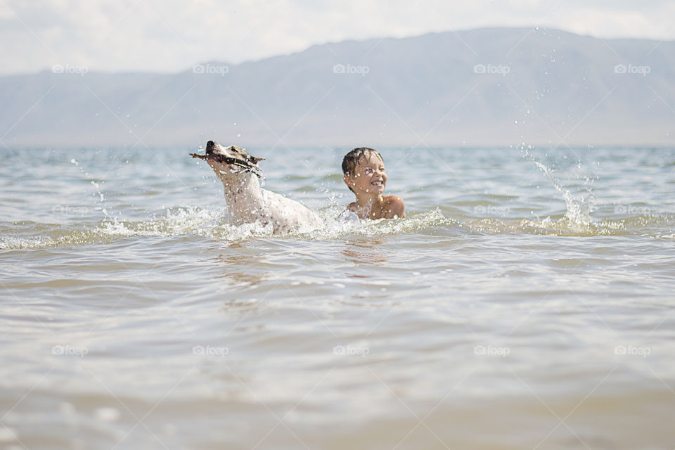 boy with dog in a water