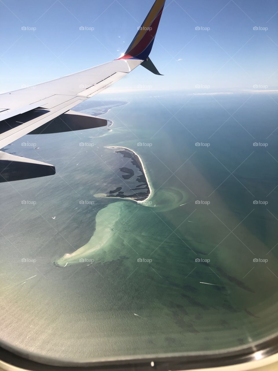 Flight over green ocean and a sandbar