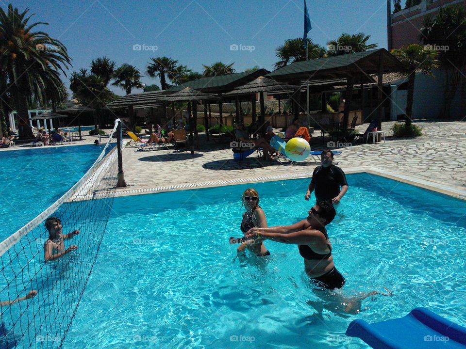 People playing volleyball in swimming pool
