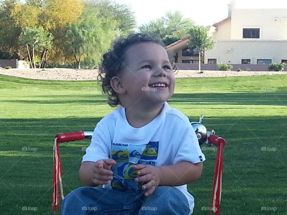 Toddler smiling in park.