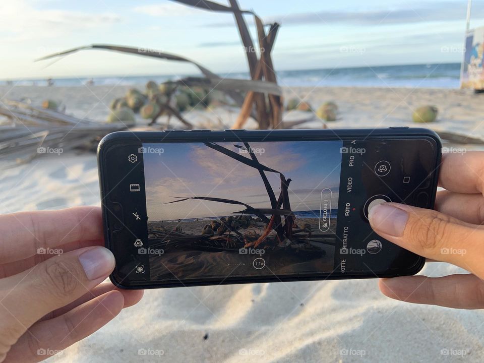 Taking pictures with phone on the beach 